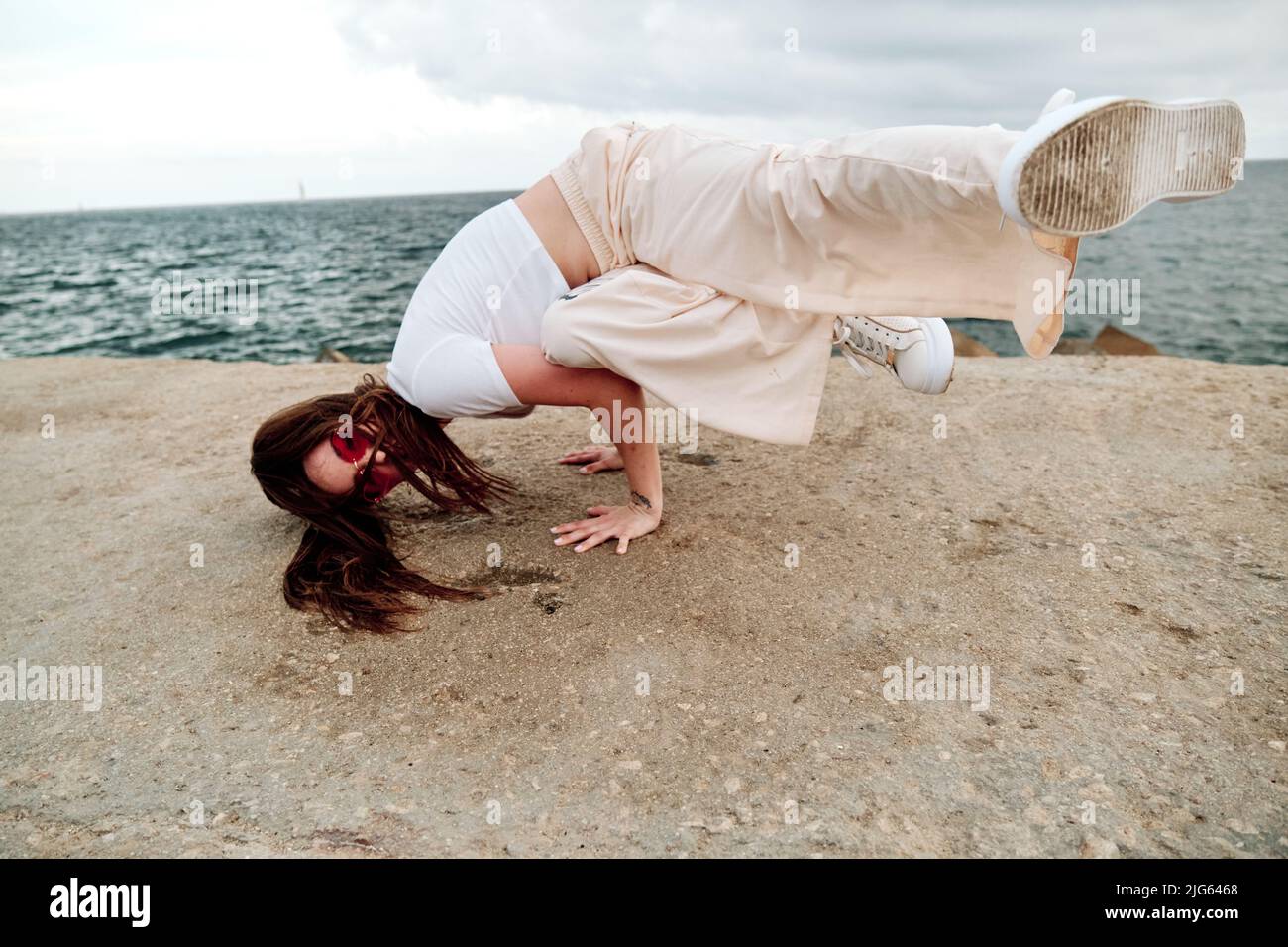 Ballerino hip-hop che si spezza all'aperto con il mare sullo sfondo. Foto Stock
