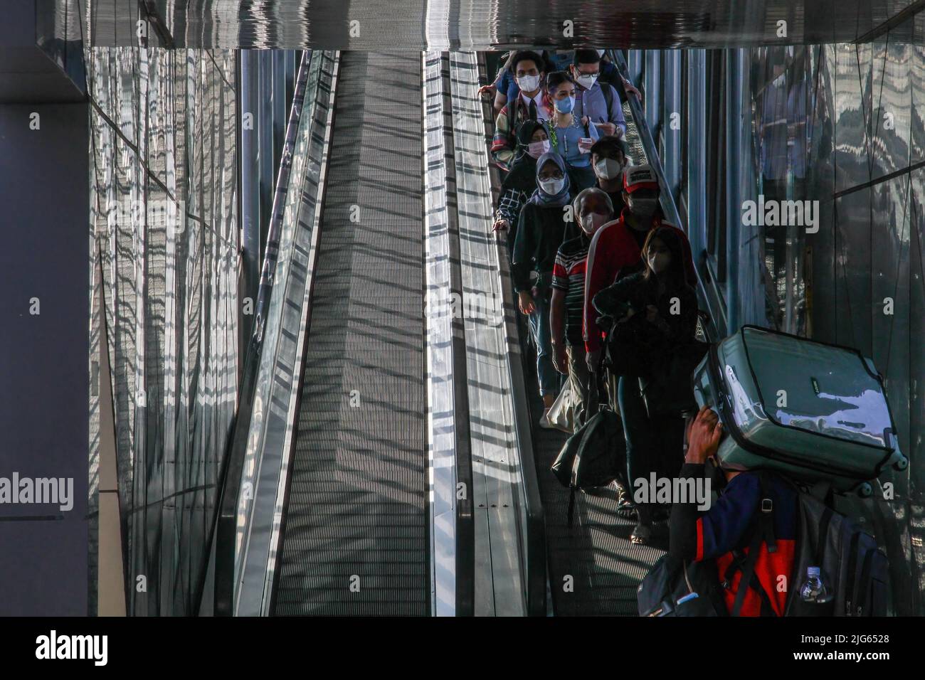 Bandung, Indonesia. 08th luglio 2022. I passeggeri che indossano maschere facciali camminano verso il treno alla stazione ferroviaria di Bandung. Il governo indonesiano implementerà un vaccino di richiamo per il Covid-19 nelle prossime due settimane come requisito per i viaggiatori. Credit: SOPA Images Limited/Alamy Live News Foto Stock