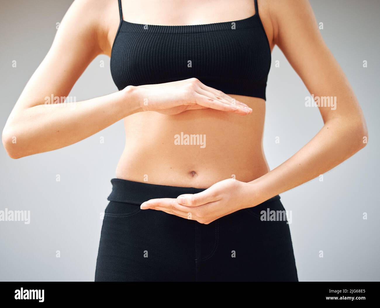 Costruendo quel collegamento di budello di mente. Colpo di una donna che forma un cerchio con le mani davanti al suo ventre. Foto Stock