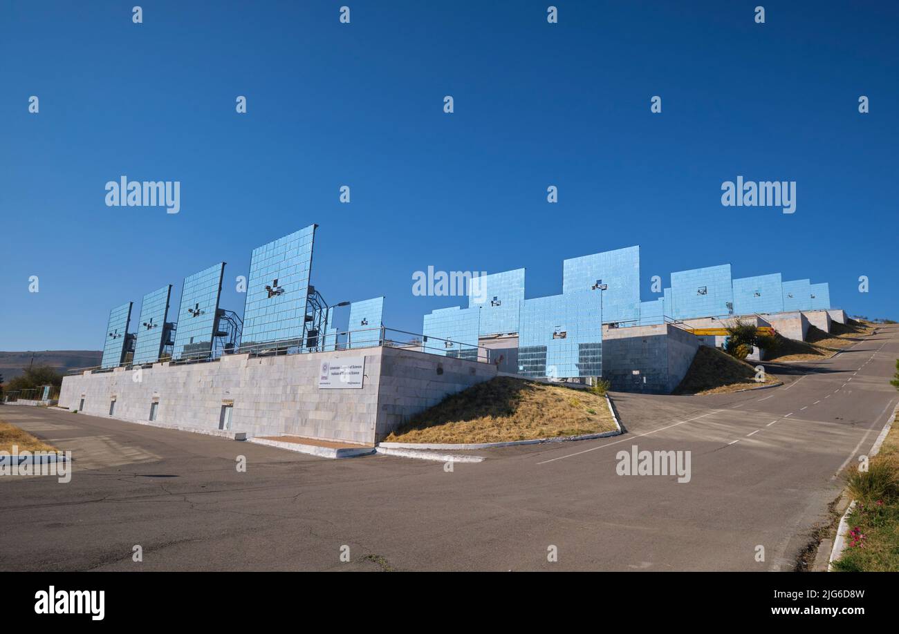 Le file di specchi che dirigano la luce sul concentratore gigante curvo presso il Physics of the Sun Institute of Physics and Technology. In Parkent, Foto Stock