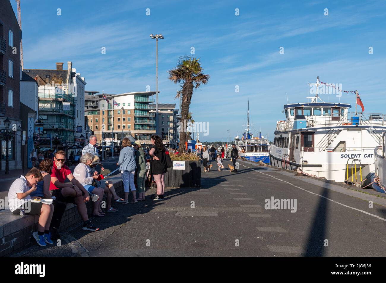 Famiglie in vacanze estive o in staycats godendo il lungomare a Poole Quay, Dorset, Inghilterra, Regno Unito, in una giornata di sole Foto Stock