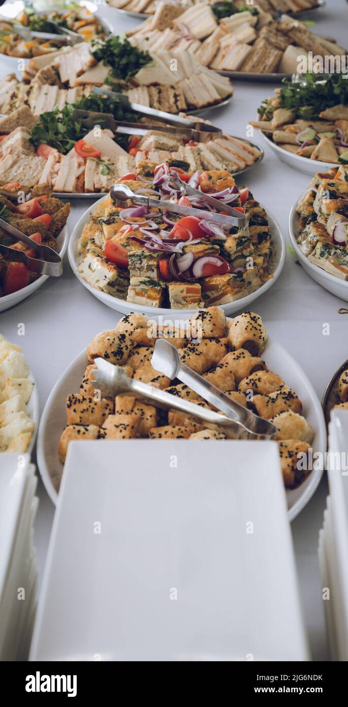 Un tavolo pieno di cibo Party disposto su piatti pronti a mangiare in una parte utilizzando fuoco selettivo Foto Stock
