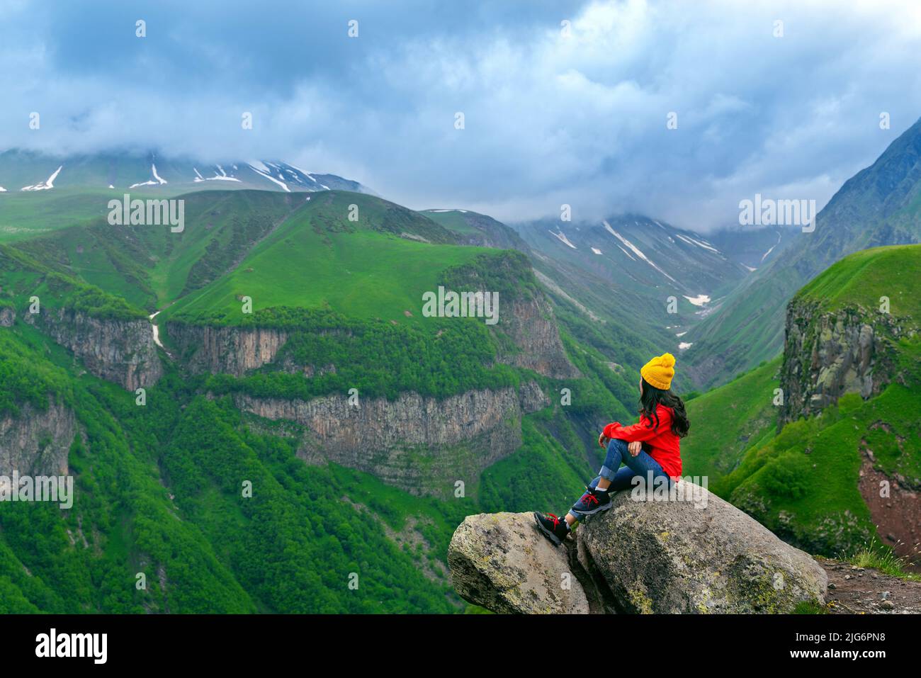 Tourist sedendosi e godere di vista vicino al monumento russo di amicizia georgiana, Georgia. Foto Stock