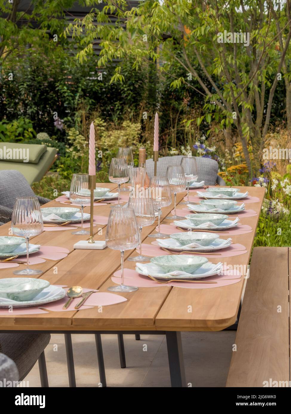 Tavolo da giardino in legno allestito per una cena in un giardino con spettacolo all'Hampton Court Palace Garden Festival. Londra. Foto Stock