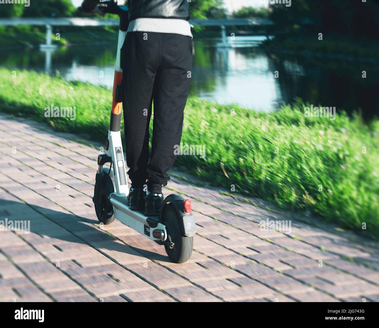 giovane uomo su uno scooter elettrico sul lungomare urbano Foto Stock