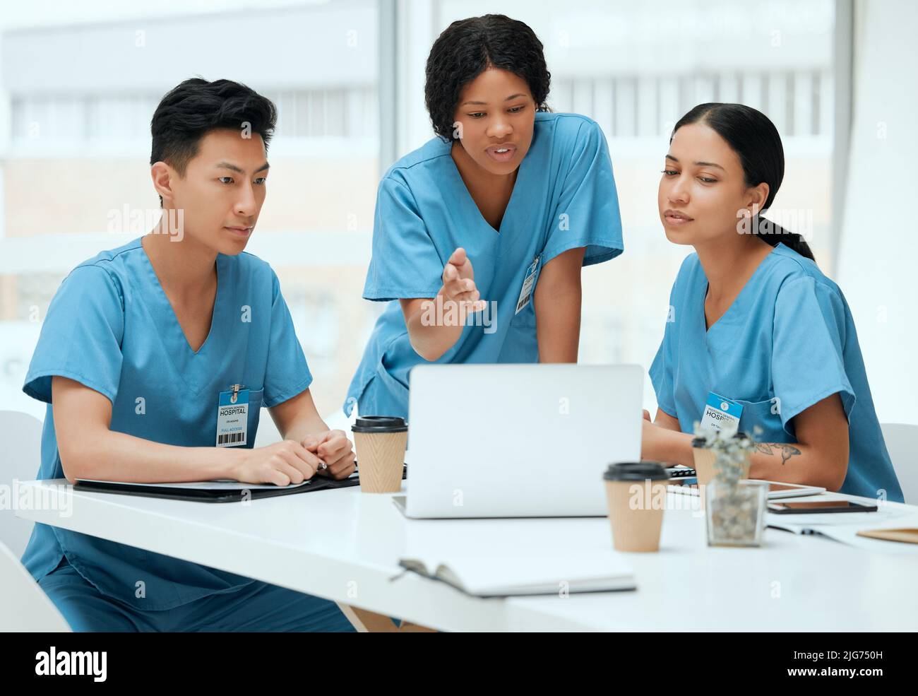 Lascia capire questo fuori. Shot di un gruppo di giovani medici in una riunione in un ospedale. Foto Stock