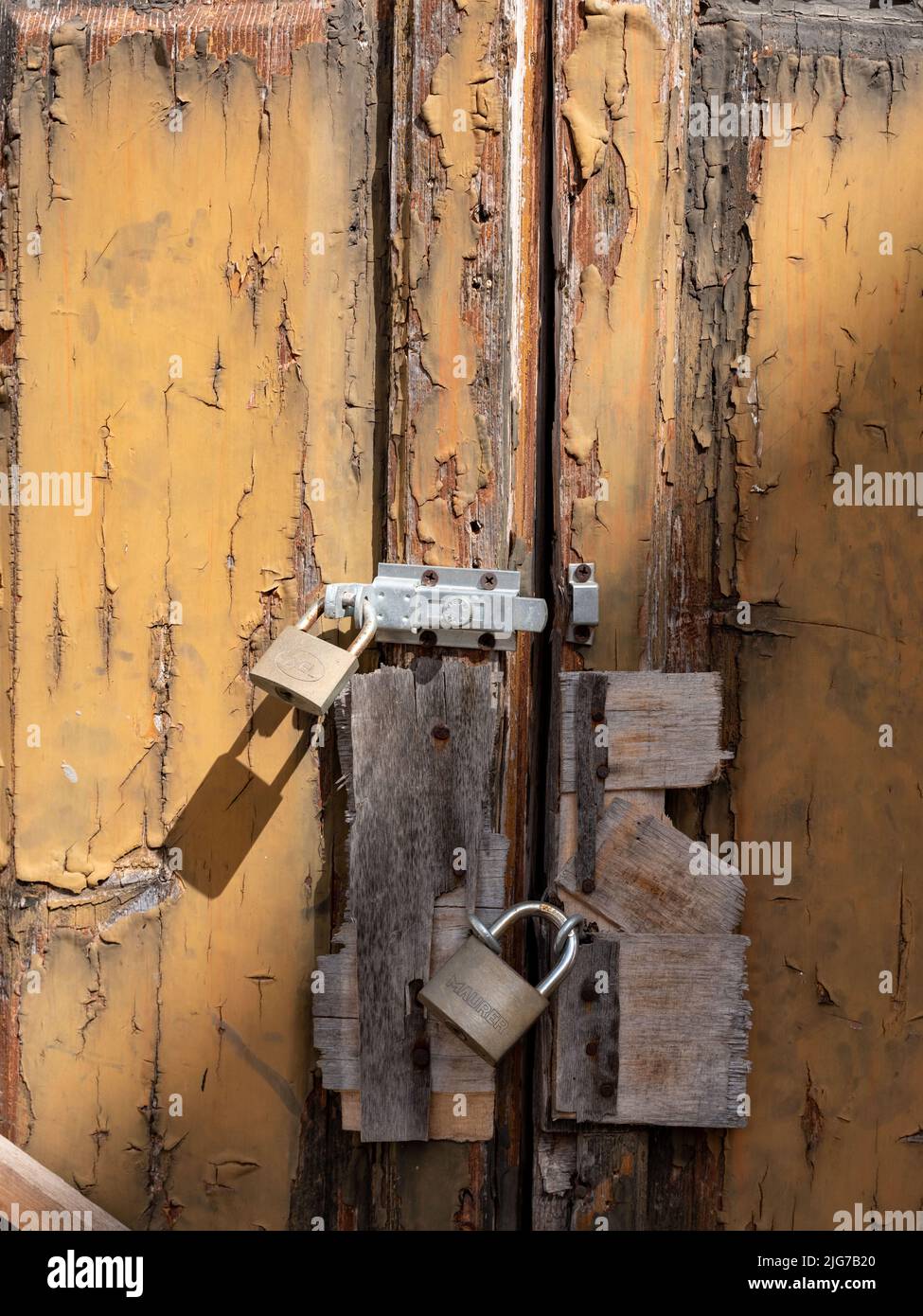 Serrature multiple attaccate ad una porta in legno maltempo a una vecchia casa nella città di Nardo, Puglia, Italia. Foto Stock