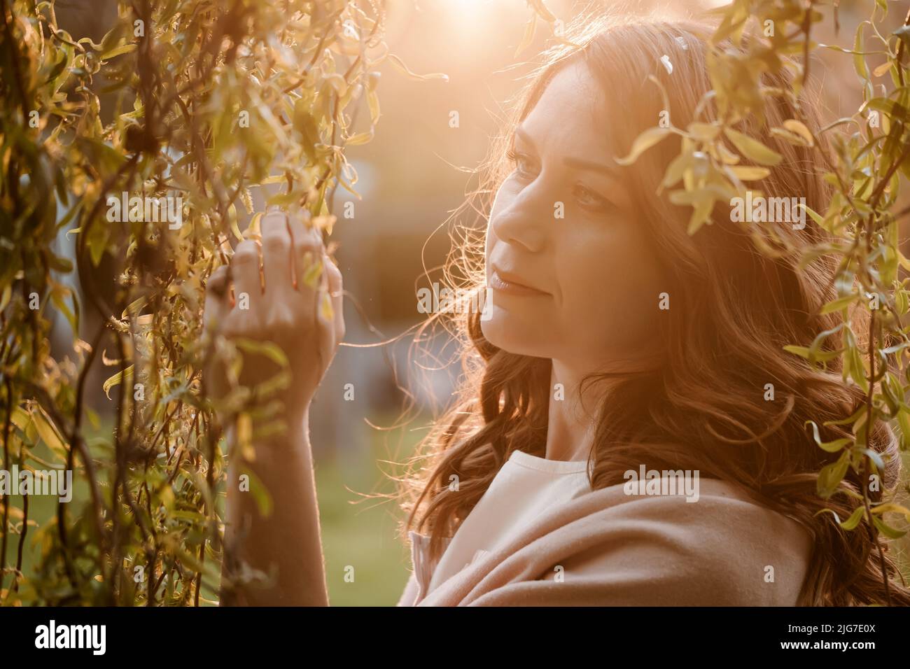 Bella donna romantica godendo la natura primaverile al tramonto. Ritratto in primo piano con trucco naturale Foto Stock