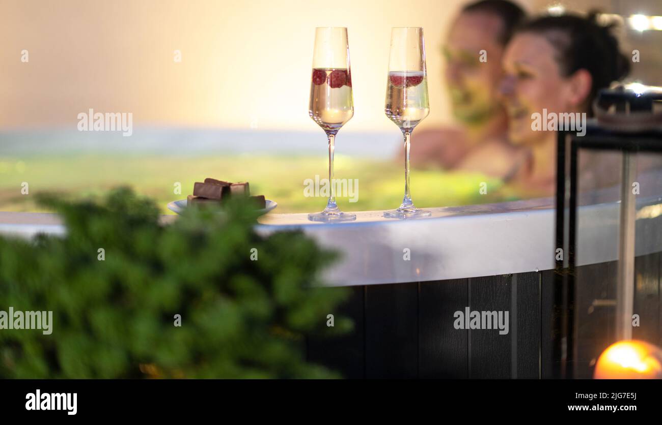 Incontri Coppie relax nel Garden SPA. Due bicchieri di champagne e cioccolato sul bordo della vasca idromassaggio. Foto Stock