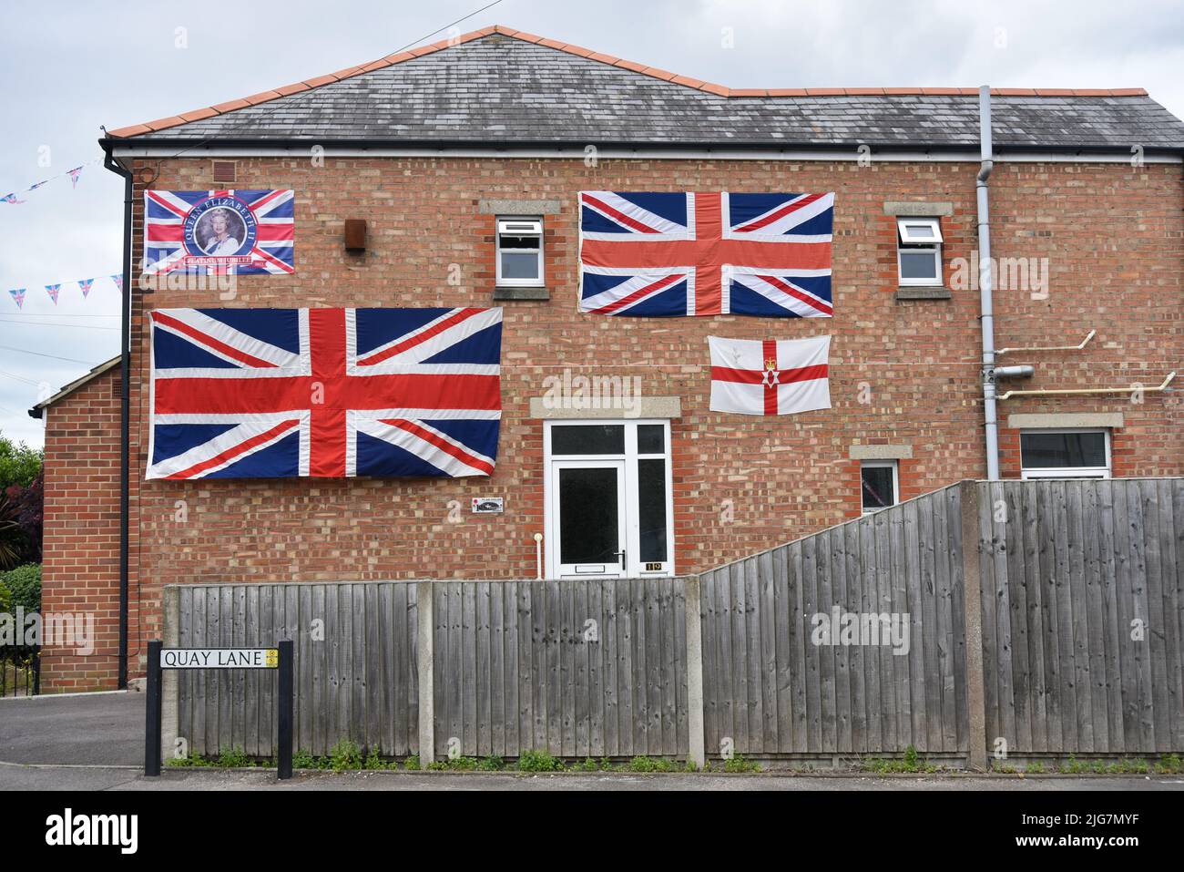 Residenza inglese residenziale decorata con bandiere unioni jack e la bandiera dell'Irlanda del Nord in commemorazione del giubileo della regina Elisabetta. Foto Stock