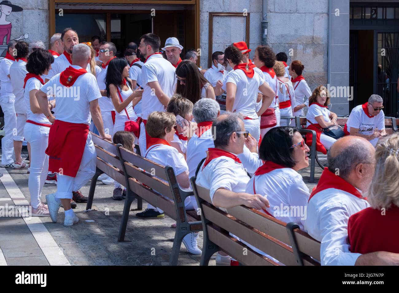 Persone in strada che godono l'atmosfera del festival San Fermin in tradizionale abbigliamento bianco e rosso con cravatta rossa. Luglio 07 2022. Pamplona Foto Stock