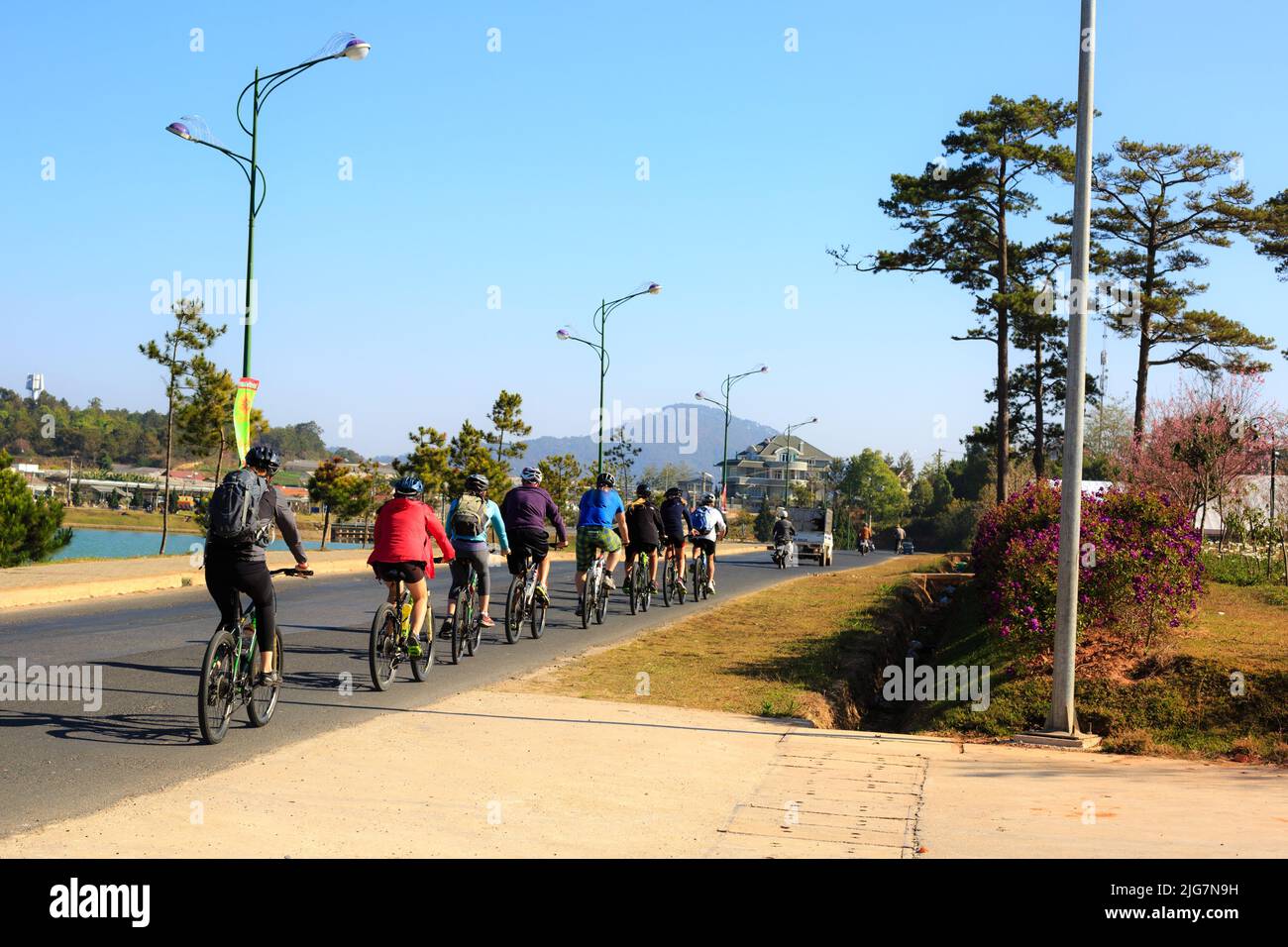 Da Lat città, Vietnam - 11 febbraio 2015: I turisti in bicicletta su strada Dalat in una mattinata di sole. Dalat molto adatto per le attività sportive, il temperat Foto Stock