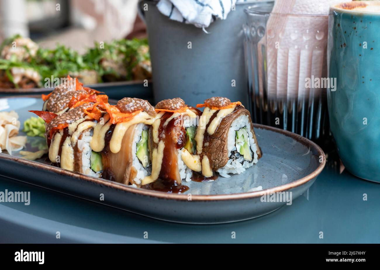 involtini di sushi vegano con caviale di melanzane chia e patate dolci in un caffè sano cibo vegetariano cucina asiatica fuoco selettivo Foto Stock