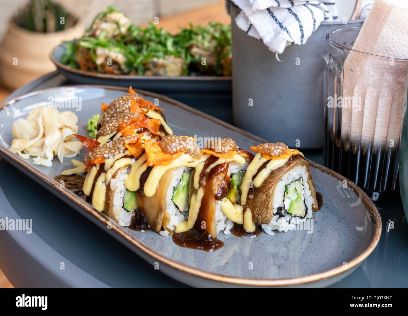 involtini di sushi vegano con caviale di melanzane chia e patate dolci in un caffè sano cibo vegetariano cucina asiatica fuoco selettivo Foto Stock