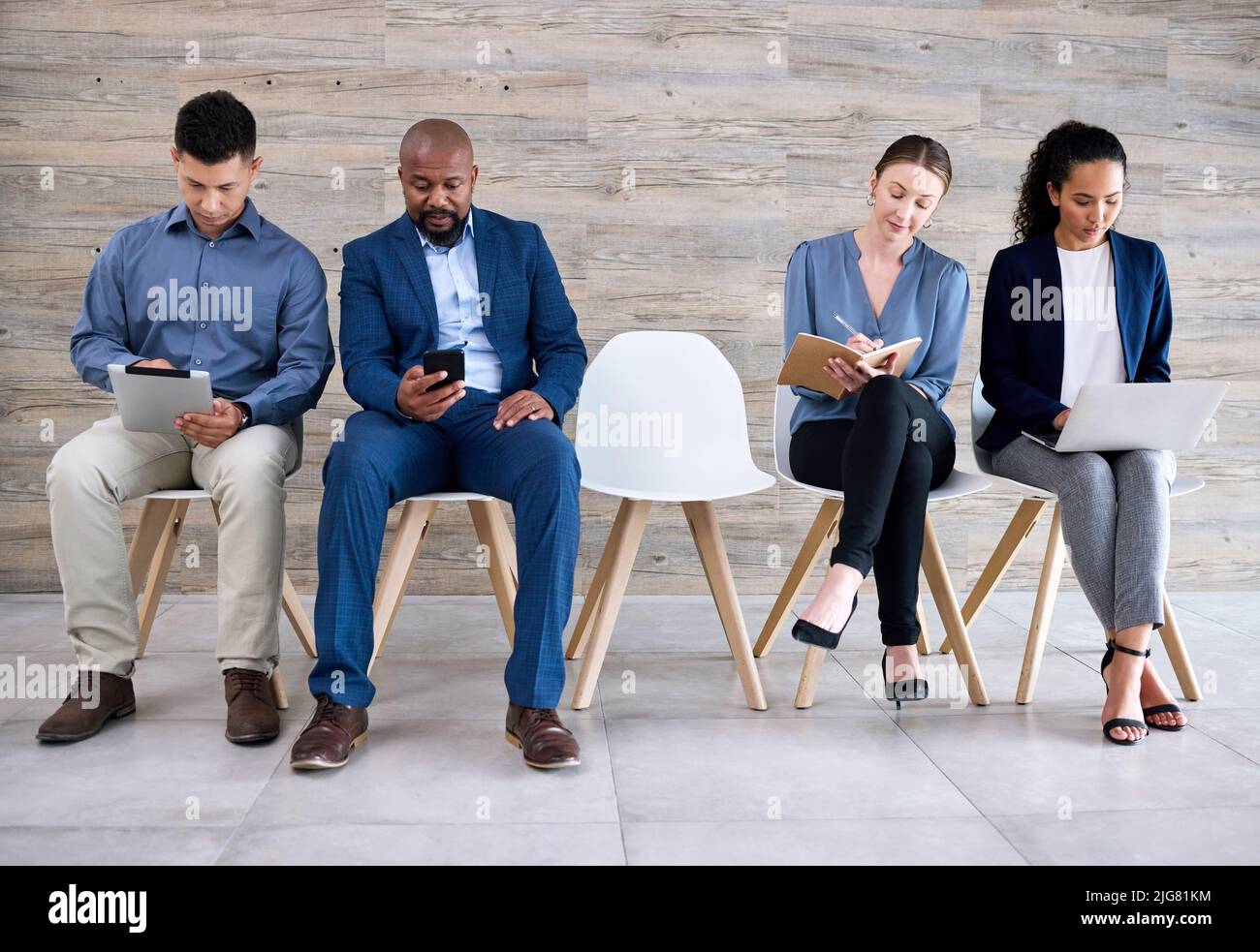 Chi otterrà l'ultimo posto. Sparato di un gruppo di uomini d'affari in attesa in linea in un ufficio. Foto Stock