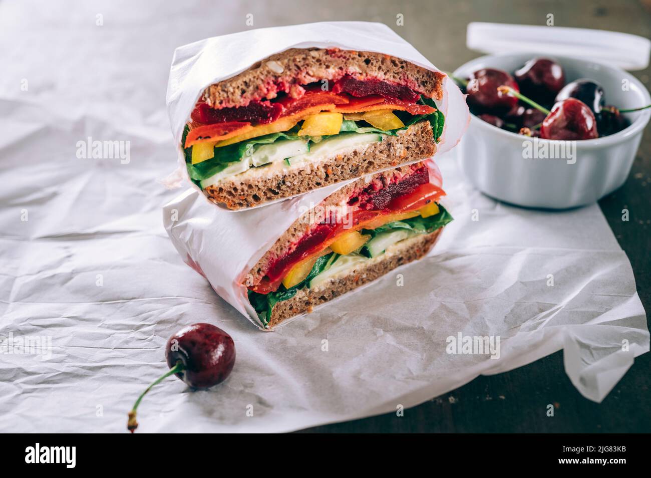 Sandwich con verdure colorate, barbabietola, pomodoro, carota, peperone, insalata, cetrioli e hummus sparsi Foto Stock