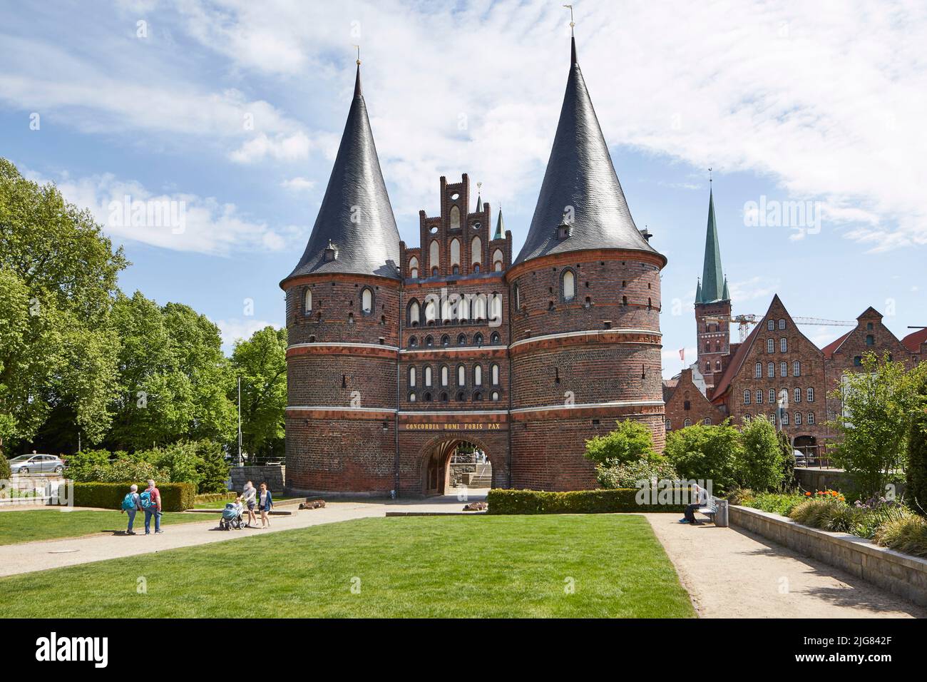 Germania, Schleswig-Holstein, Lübeck, porta Holsten, sullo sfondo gli storici magazzini del sale e la torre della Chiesa di San Pietro Foto Stock