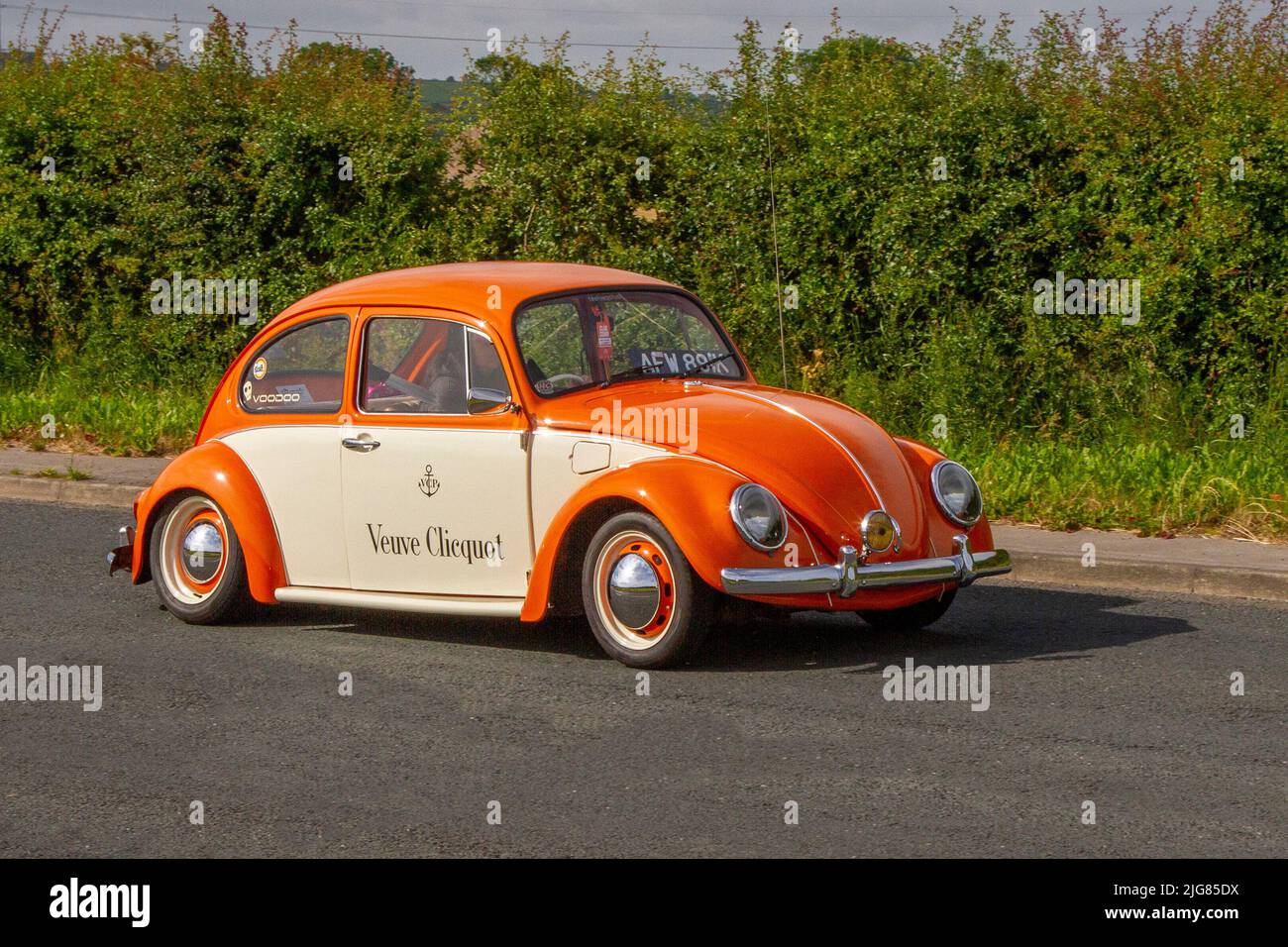 Pubblicità Veuve Clicquot anni '1972 70 arancio crema vecchio tipo VW Volkswagen Beetle 1192 cc benzina, auto d'epoca raffreddata ad aria. Veicoli su misura in viaggio verso la Hoghton Tower per il Supercar Summer Showtime Meet, organizzato dai Great British Motor Show di Preston, Regno Unito Foto Stock