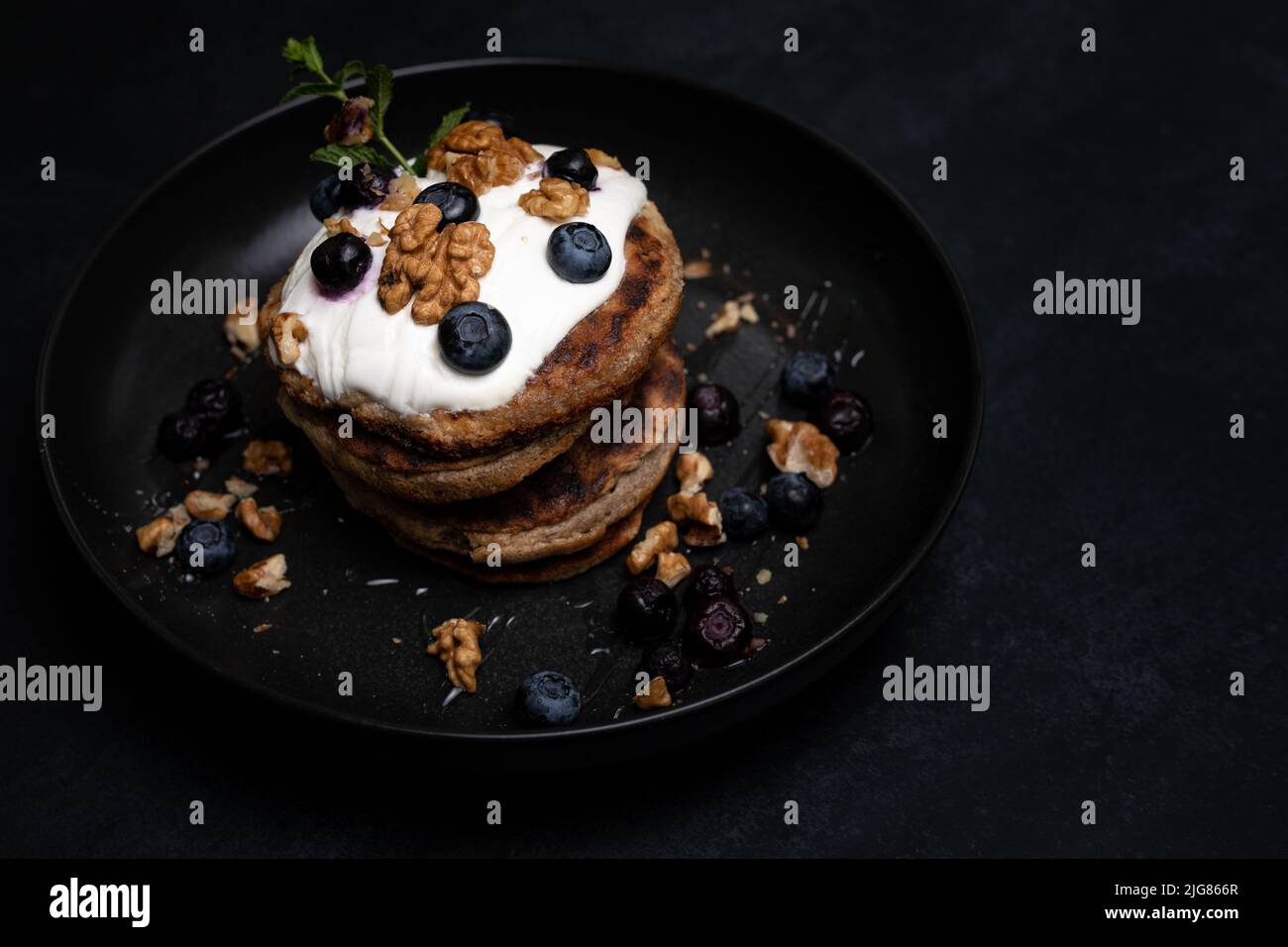 Colazione perfetta, pancake americani accatastati serviti su un tavolo di pietra nera. Cluse up Foto Stock