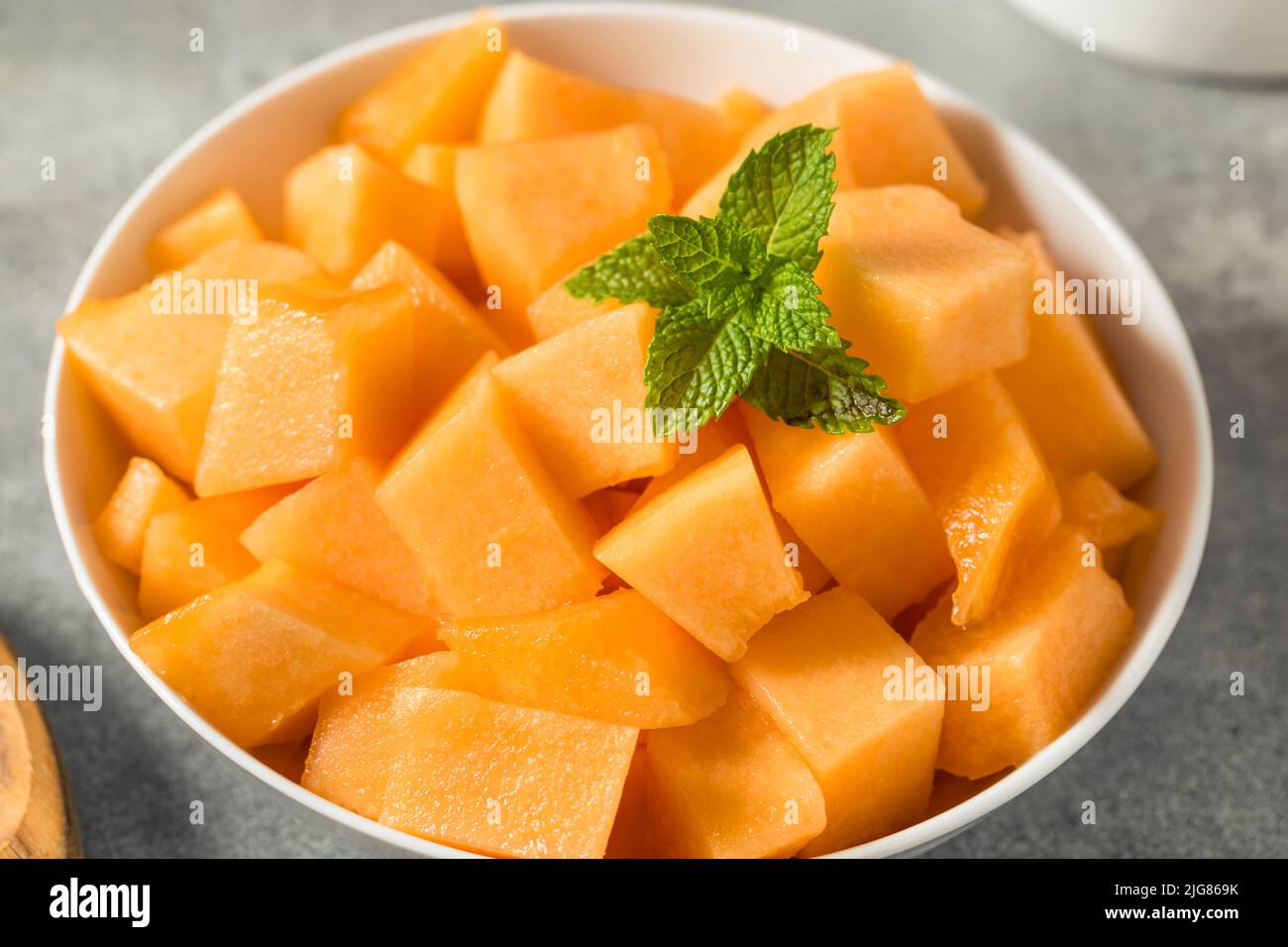 Melone organico di Cantaloupe crudo arancione tagliato a cubetti Foto Stock