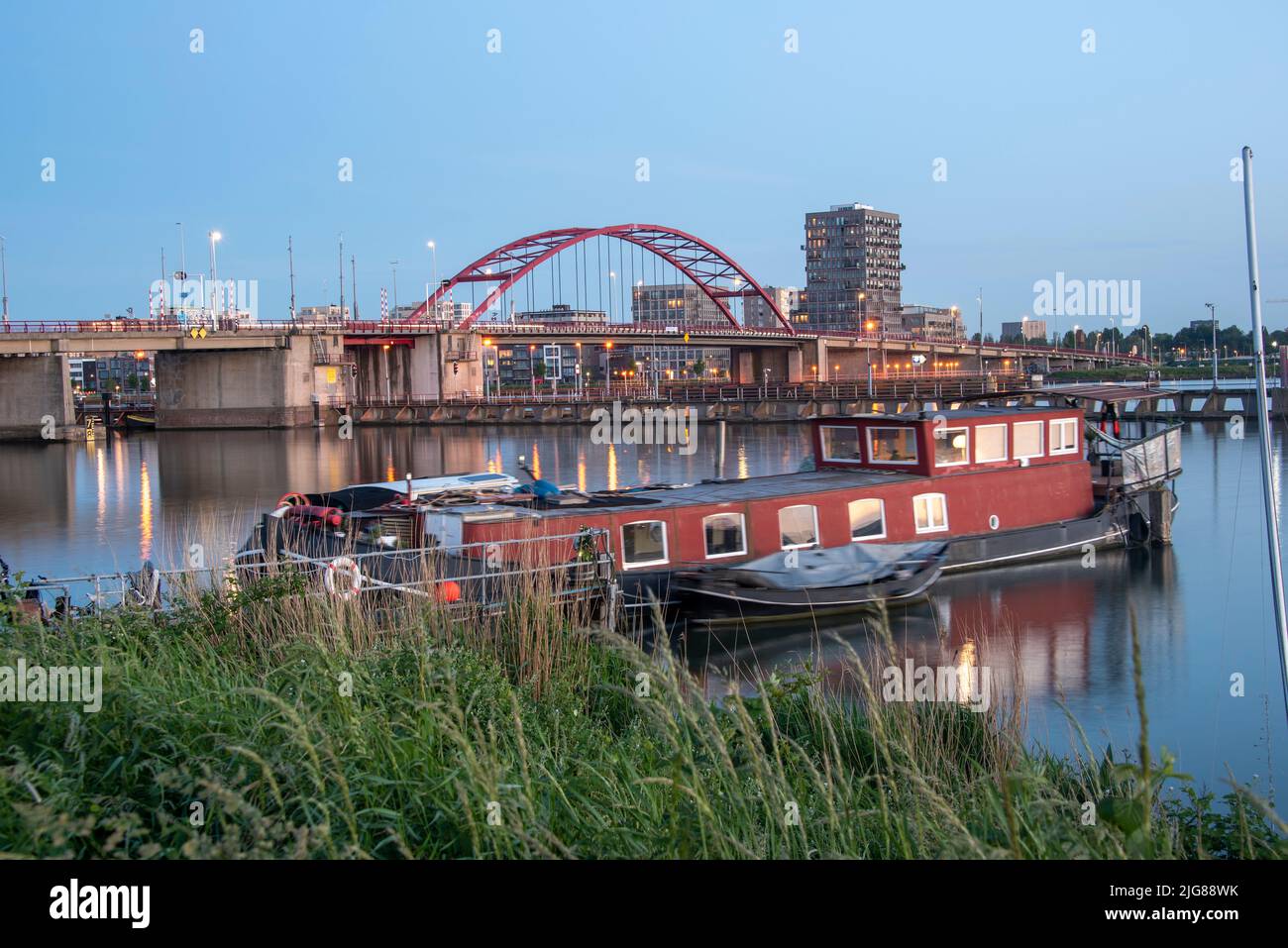 Houseboat, nave residenziale, ponte e grattacieli dietro, Noord distretto, Amsterdam, Paesi Bassi Foto Stock
