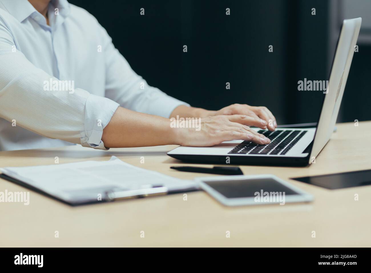 Foto ravvicinata di un uomo d'affari che lavora e digita su una tastiera di un laptop, un manager che lavora in ufficio a un tavolo. Foto Stock