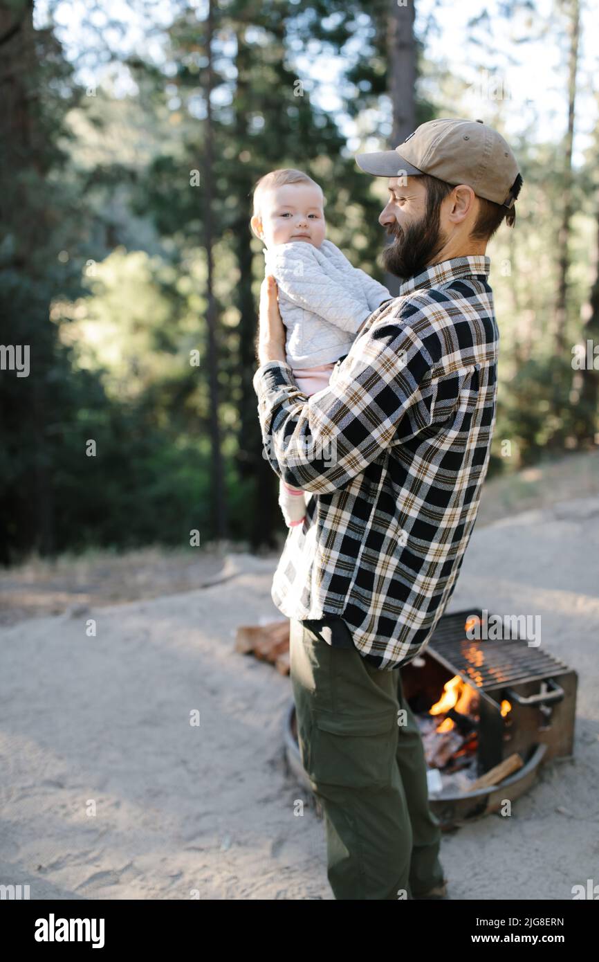 Una verticale di un padre caucasico con la figlia del bambino che gioca insieme e accampandosi nei boschi Foto Stock