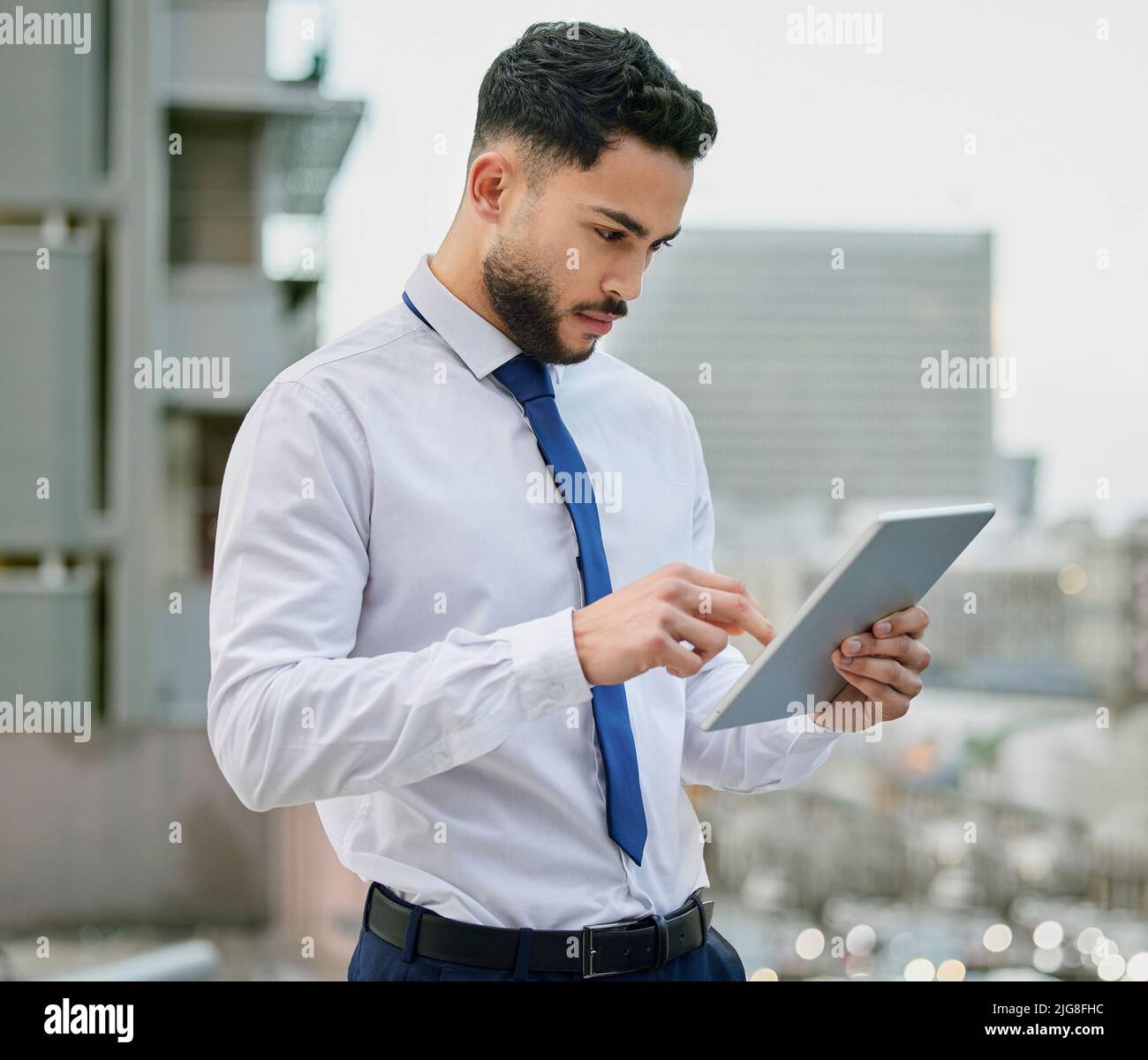 I dispositivi continuano a portarmi delusioni. Scatto di un giovane uomo d'affari che usa un tabley digitale. Foto Stock