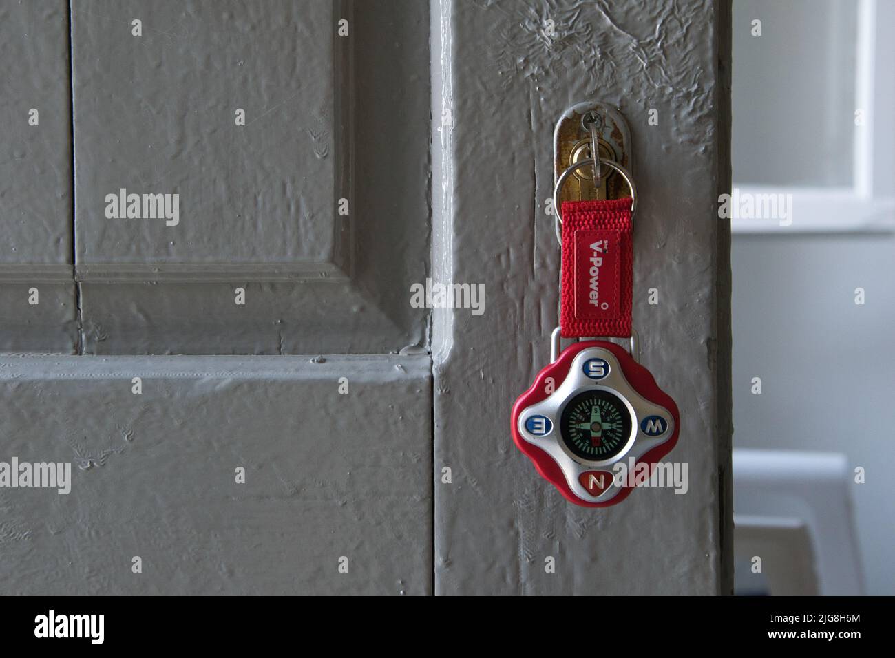 chiave sulla vecchia bella porta con bussola portachiavi Foto Stock