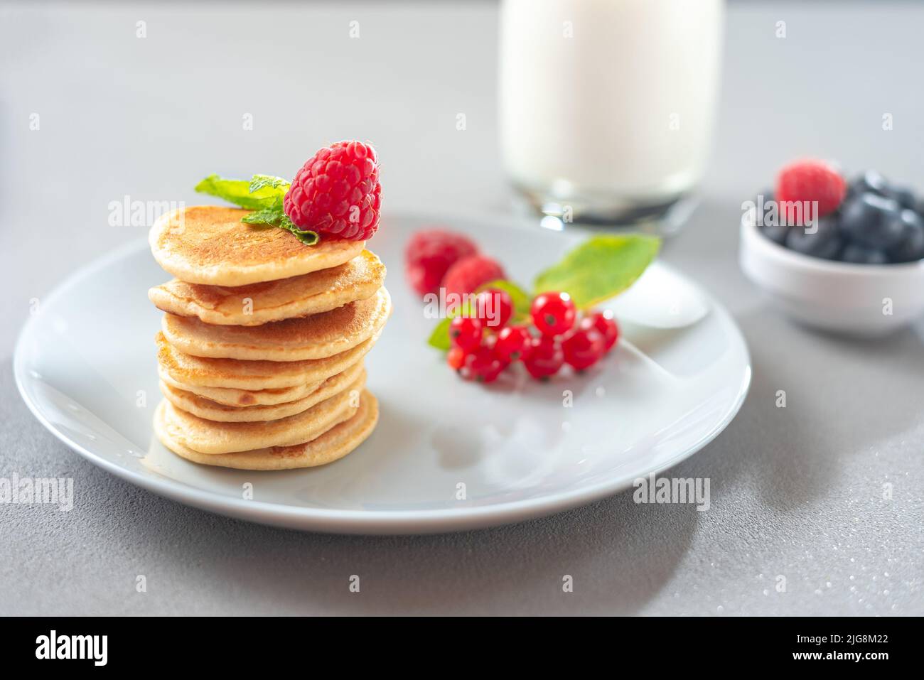 Pancake con frutti di bosco su un piatto bianco. American Pancake Mini Pancakes con frutti di bosco Foto Stock