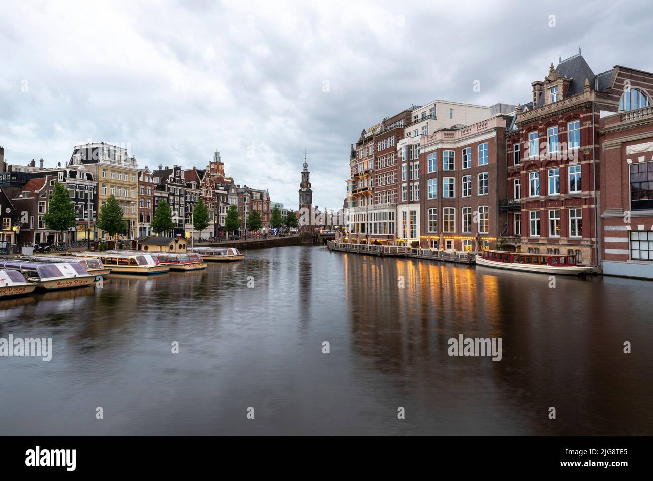 Edifici residenziali di Amsterdam, torre dell'orologio di Montelbaanstoren, Dawn, Amsterdam, Noord-Holland, Paesi Bassi Foto Stock