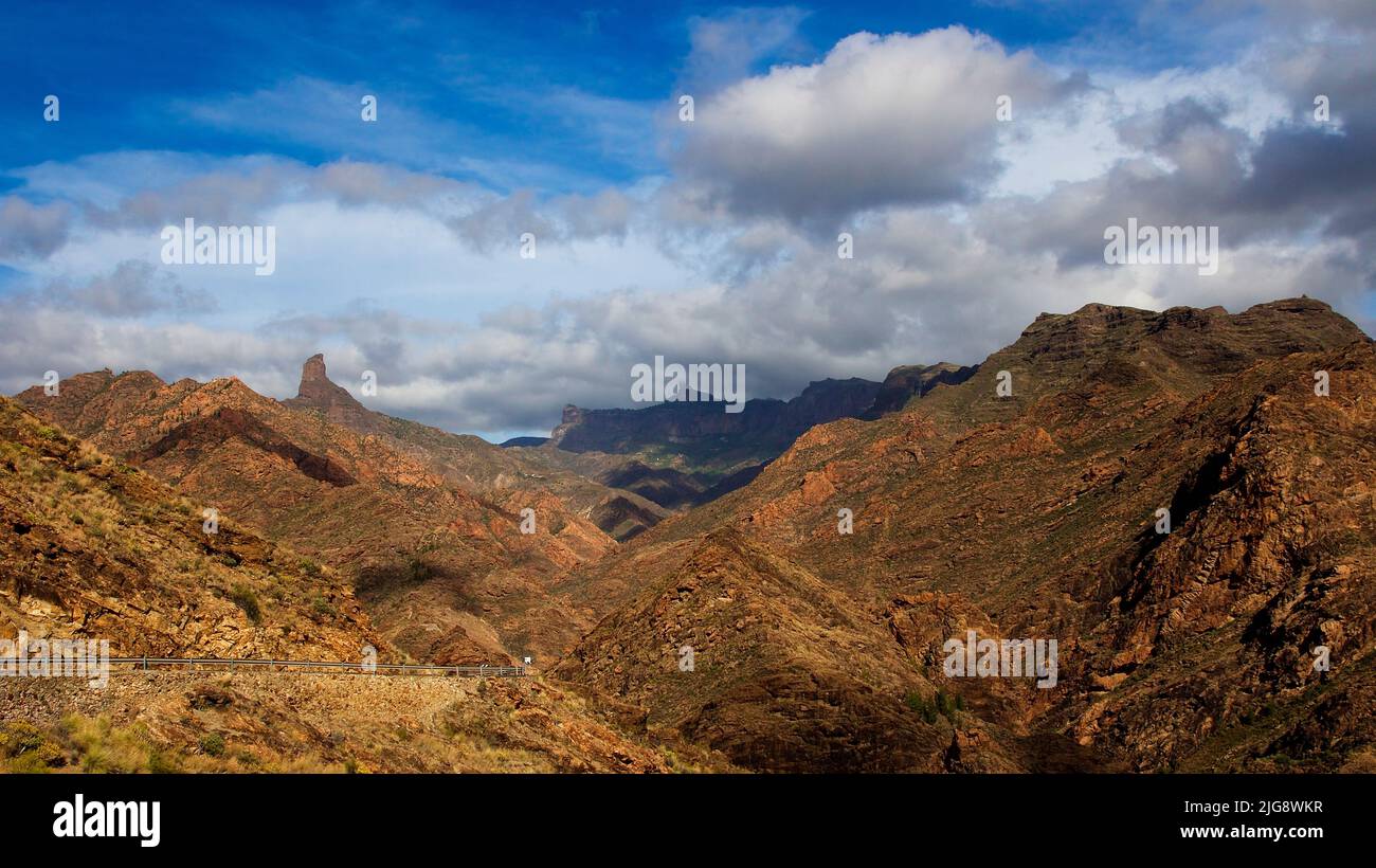 Spagna, Isole Canarie, Gran Canaria, Massif Central, Barranco de la Aldea, vista sul barranco a nord di Roque Bentayga e Roque Nublo, cielo blu con nuvole grigio-bianche Foto Stock