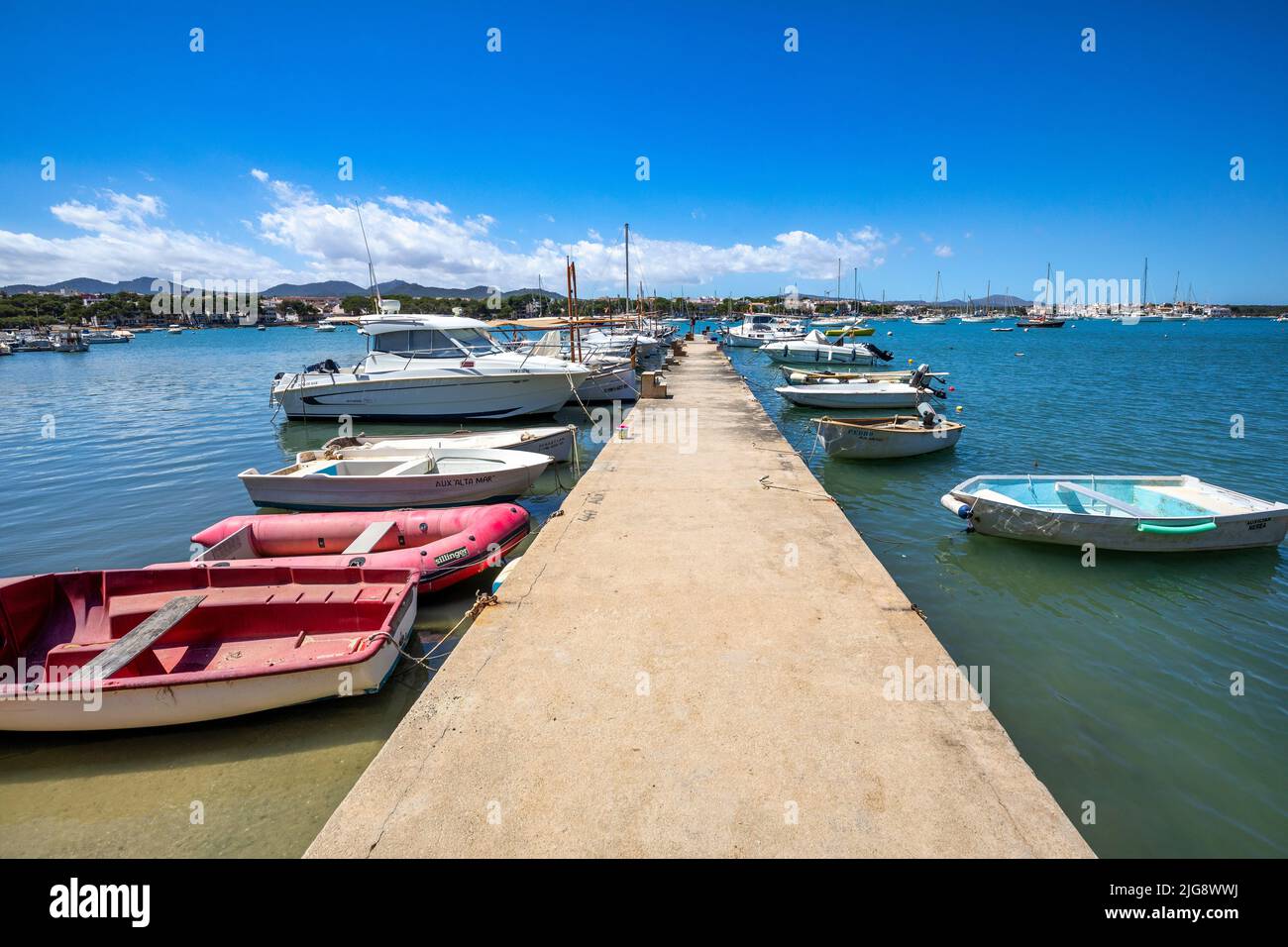 Spagna, Isole Baleari, Maiorca, distretto di Felanitx, Portocolom. Piccolo molo con barche ormeggiate nella baia di Portocolom Foto Stock