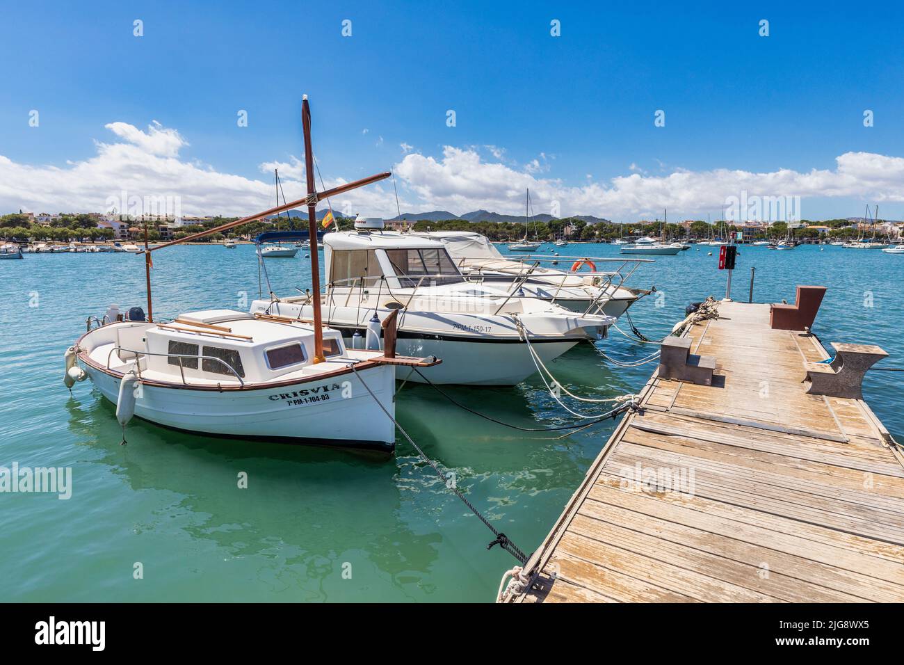 Spagna, Isole Baleari, Maiorca, distretto di Felanitx, Portocolom. Piccolo molo con barche ormeggiate nella baia di Portocolom Foto Stock