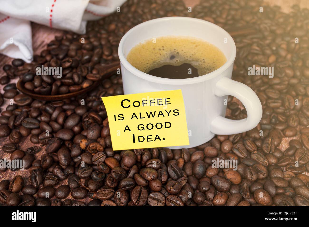 Citazione motivazionale sulla nota gialla con caffè su sfondo di legno - il caffè è sempre una buona idea. Foto Stock