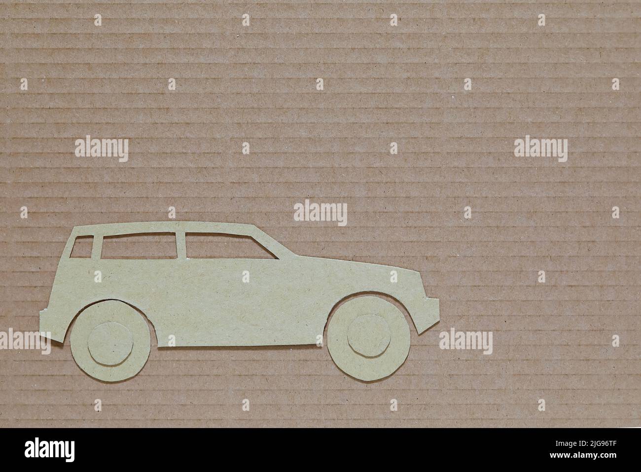 Il modello a forma di auto tagliato di cartone è posto contro un tipo diverso di cartone Foto Stock