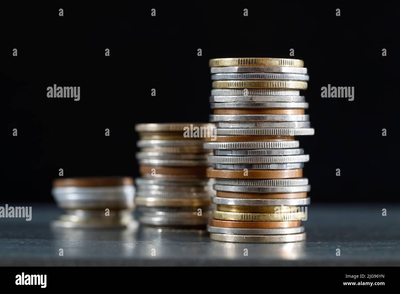 Il denaro, in questo caso un gruppo di monete impilate, rappresenta un miglioramento della situazione economica. Foto Stock