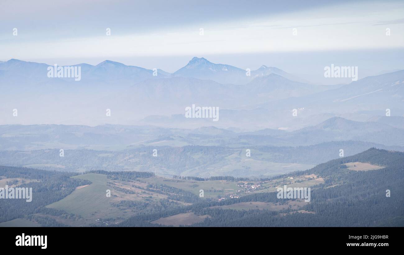 Paesaggio autunnale con valle e grandi montagne che spariscono in nebbia sullo sfondo, l'Europa Foto Stock