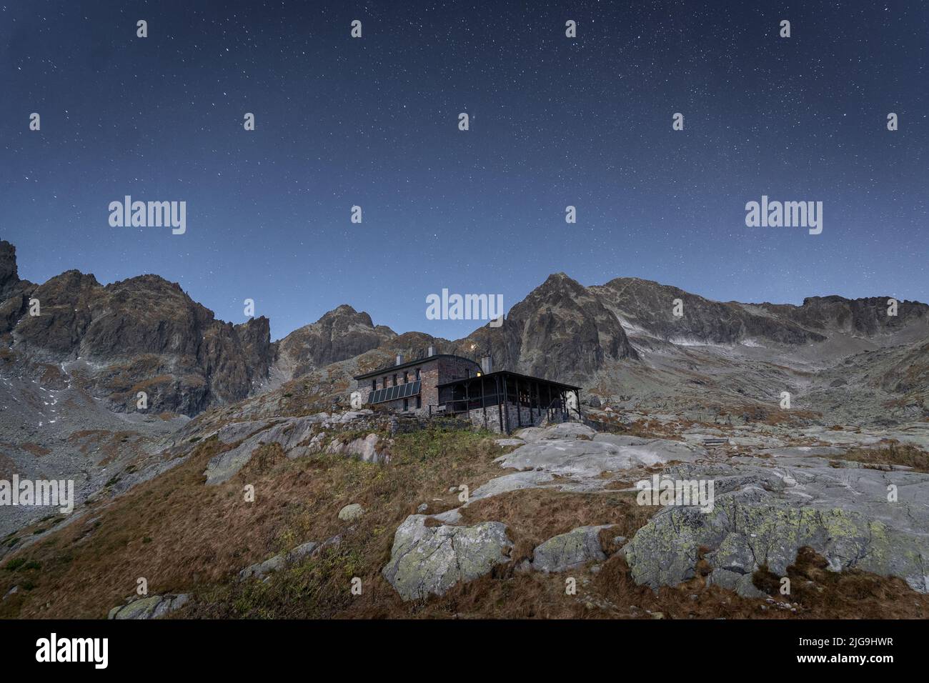 Tranquillo paesaggio alpino con cielo pieno di stelle, montagne e capanna alpina in pietra, Slovacchia, Europa Foto Stock