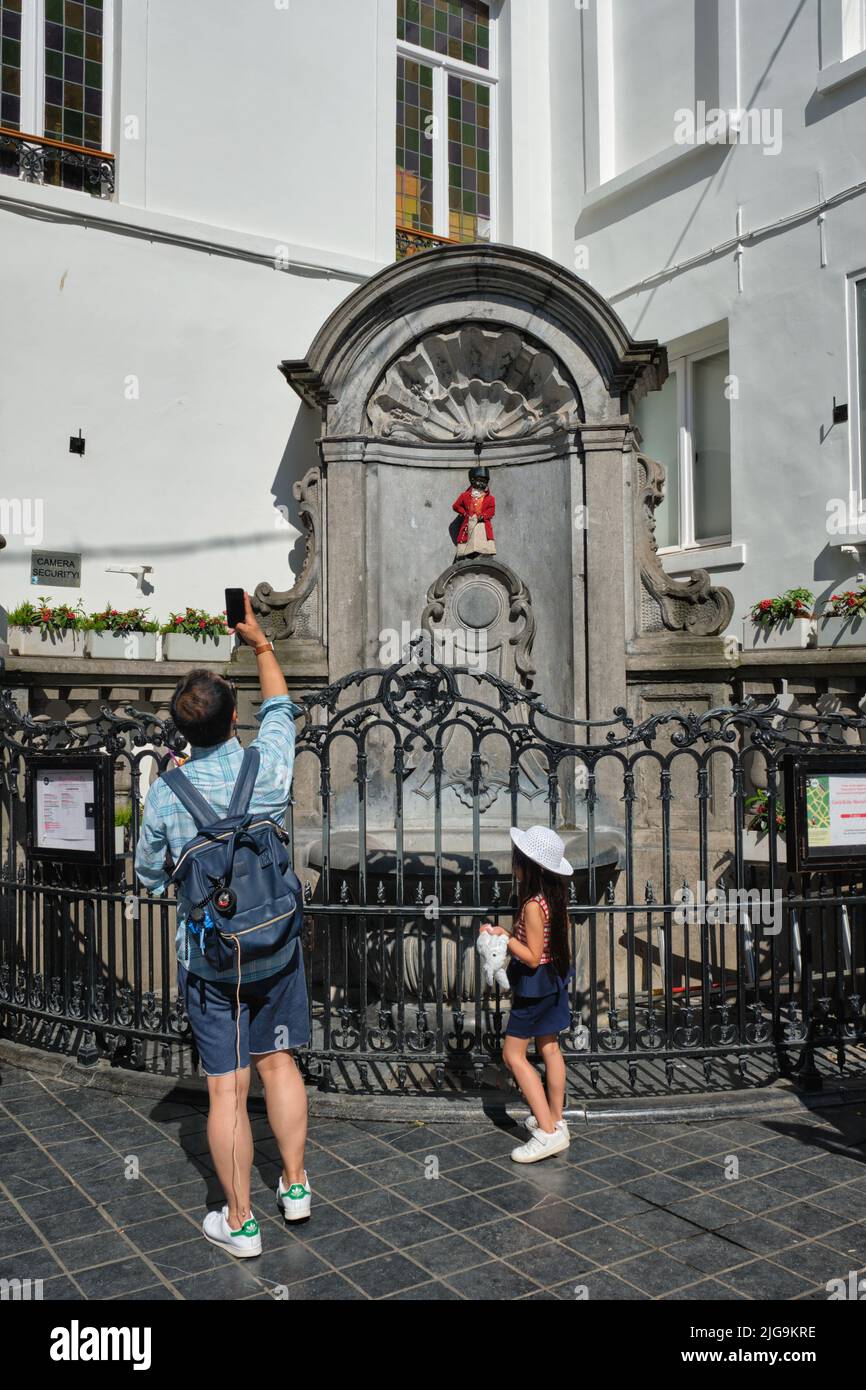 Il turista scatta foto di fronte alla famosa attrazione turistica di Bruxelles - statua di Manneken Pis Foto Stock