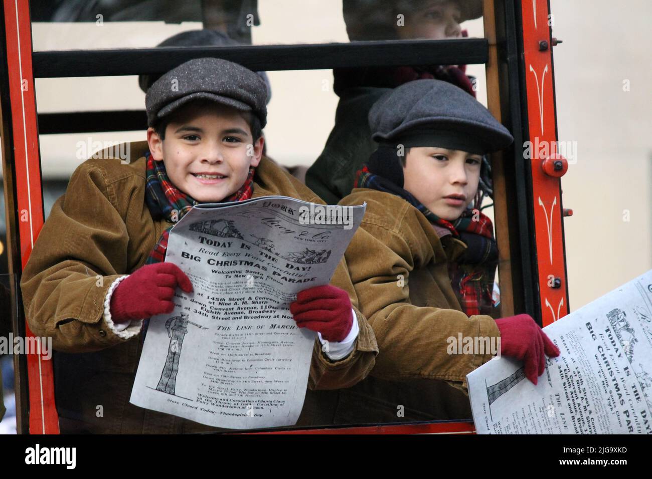 Giovani ragazzi con giornali in un camion natalizio d'epoca alla parata del giorno del Ringraziamento di Macy, New York, USA Foto Stock