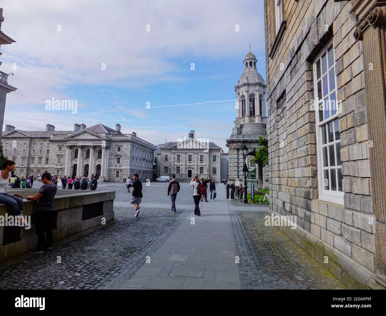 Gli studenti camminano oltre il Campanile e attraverso il cortile di Library Square al Trinity College di Dublino, Irlanda. Foto Stock