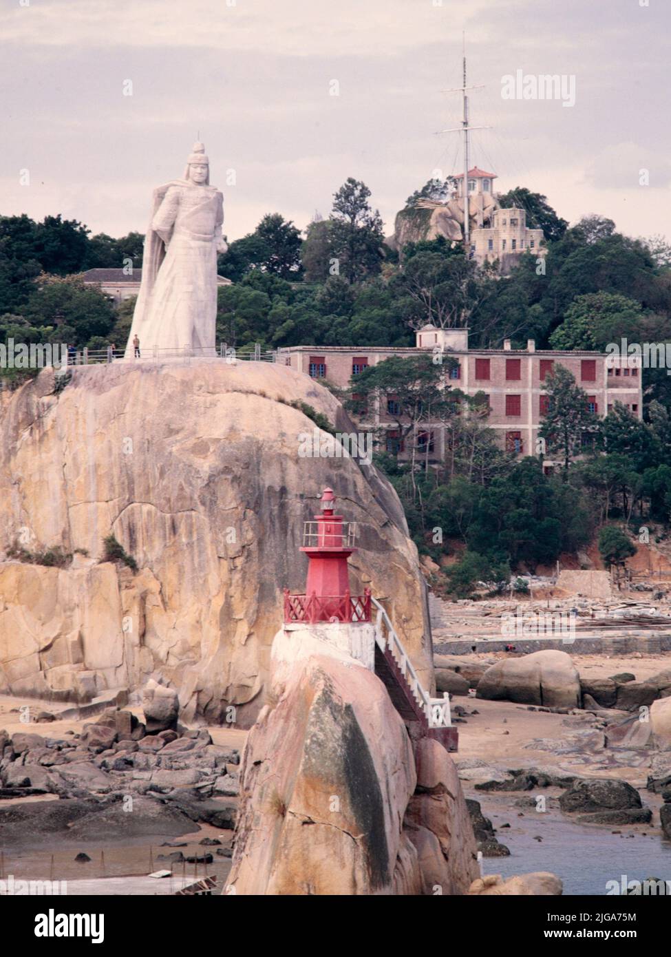 Statua del principe Koxinga, con luce solare Rock dietro, Gulangyu Island, Xiamen, (Amoy), Provincia di Fujian, Cina orientale, novembre 1986. In questa foto sono visibili alcuni edifici dell'epoca della "concessione britannica". Foto Stock