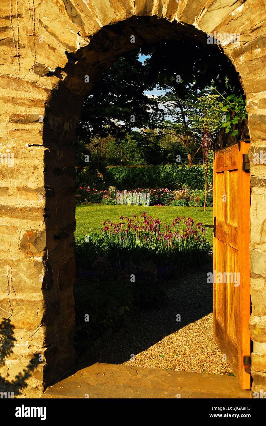 Una porta aperta ad arco e porta dà un'occhiata in un giardino segreto che è circondato da un muro di pietra nella tenuta del presidente Franklin Roosevelt Foto Stock
