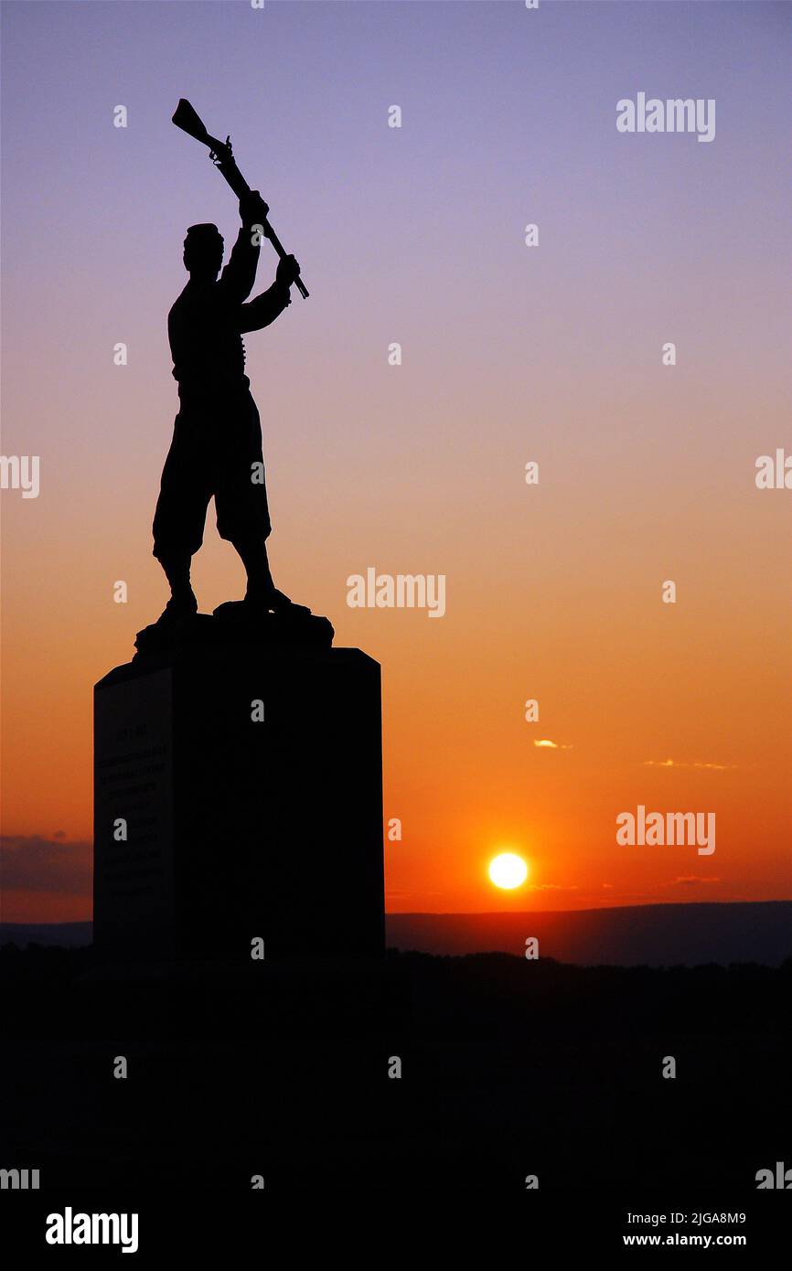 Il Memorial alla fanteria della Pennsylvania del 72nd presso il campo di battaglia della Guerra civile americana a Gettysburg raffigura un soldato che oscilla il suo fucile al tramonto Foto Stock