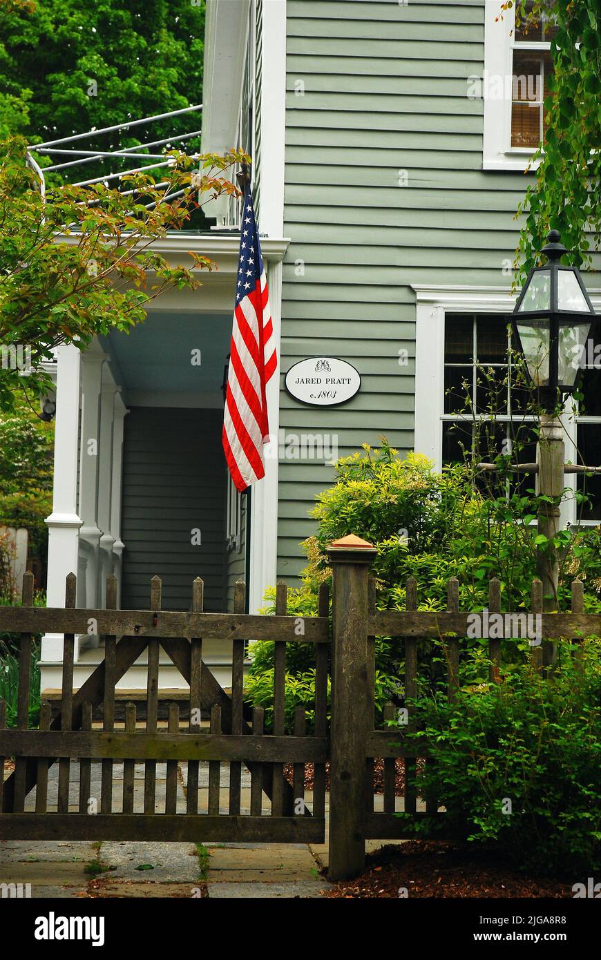 Una bandiera americana si trova davanti alla storica Jared Pratt House, una delle molte case storiche dell'Essex, Connecticut, New England Foto Stock