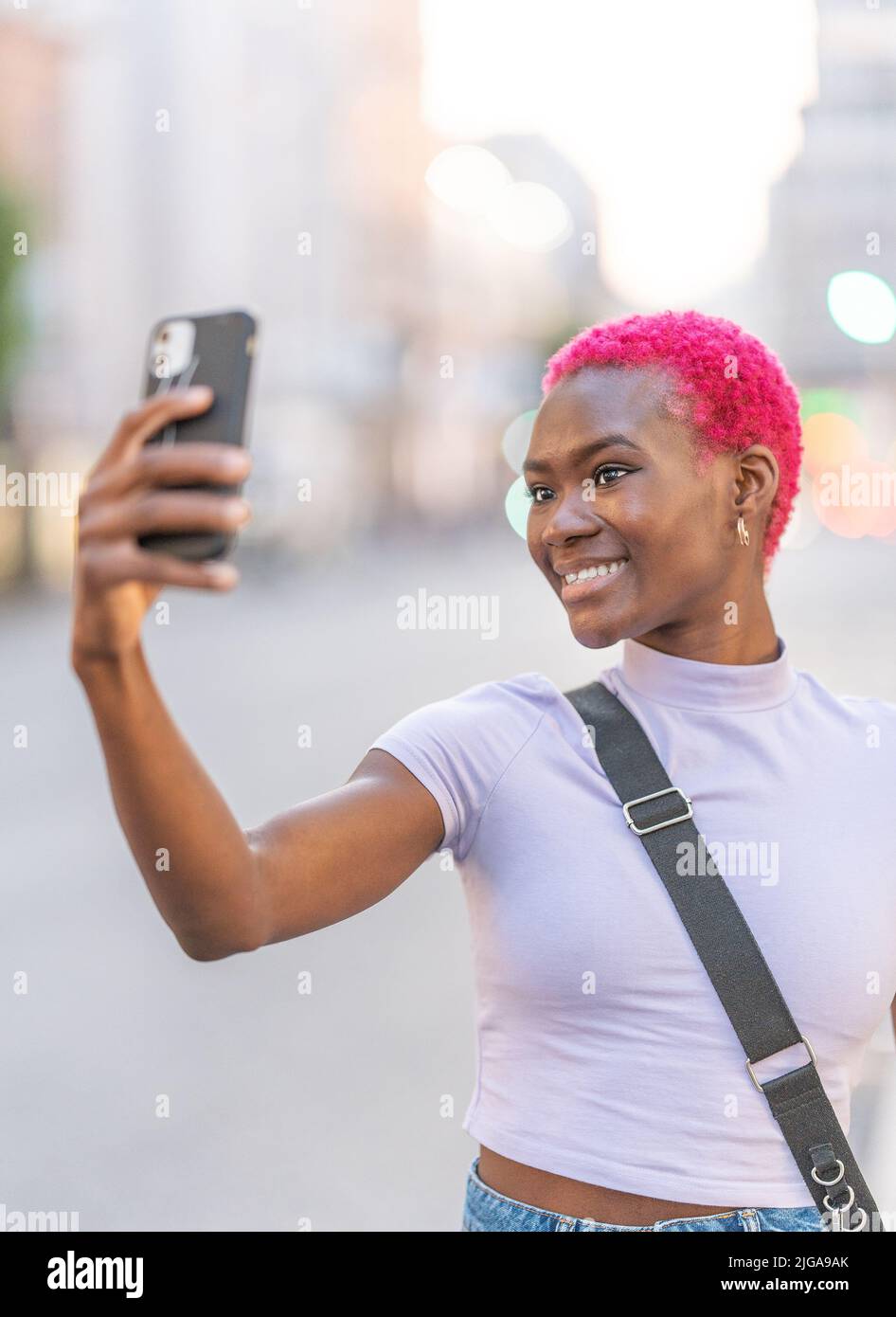Ritratto verticale di una giovane afrodonna che prende un selfie Foto Stock