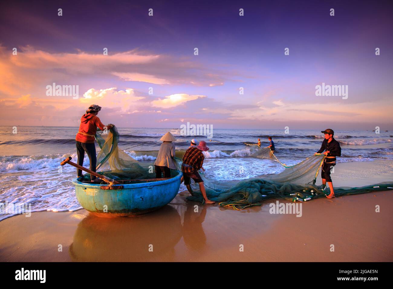 I pescatori sconosciuti che tirano in su sono le reti da pesca khi alba. Questo è chiedere il loro lavoro quotidiano Foto Stock