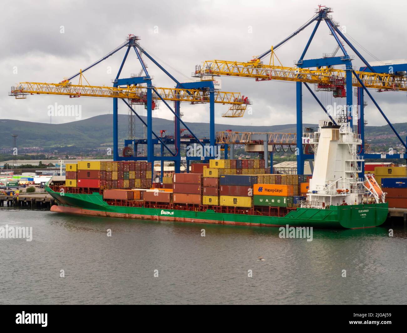 Belfast banchina il caricamento di una nave container MSC vista laterale che mostra le due gru che caricano il suo carico. Foto Stock