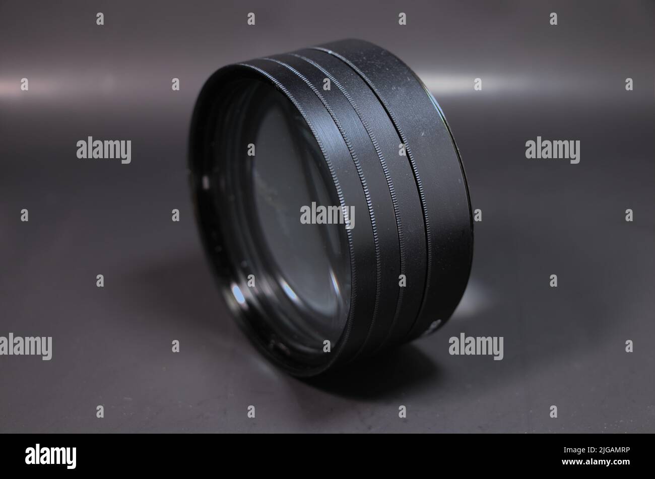 Quattro filtro obiettivo da primo piano collegato insieme e impostato su uno sfondo nero Foto Stock
